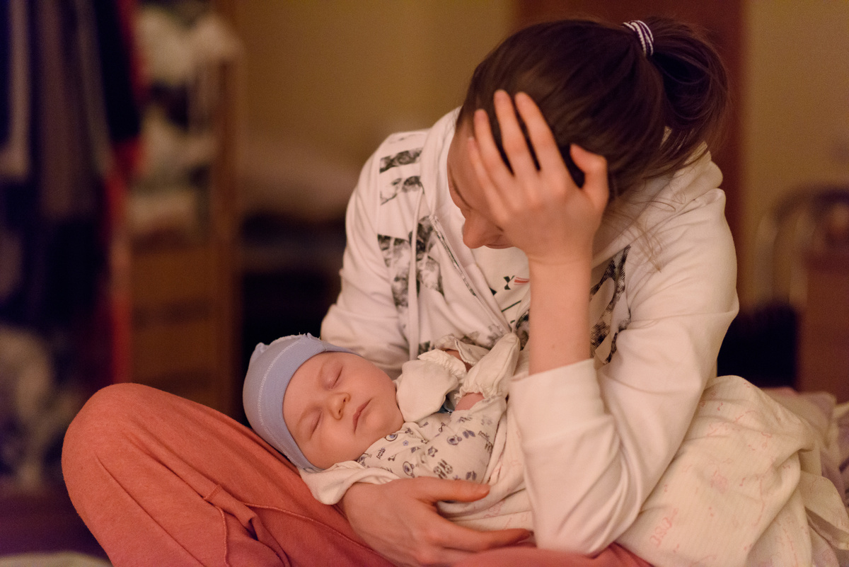 tired mother and sleeping baby